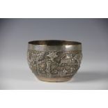 A Burmese silver bowl, the ovoid bowl embossed with figures harvesting within a landscape setting,