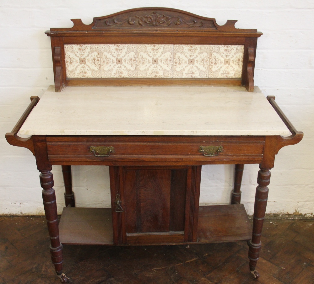 A late Victorian walnut marble top wash stand, with tile back above a drawer and cupboard door,