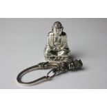 A Chinese silver vesta case, modelled as a kneeling Buddha, the base with slide opening cover,