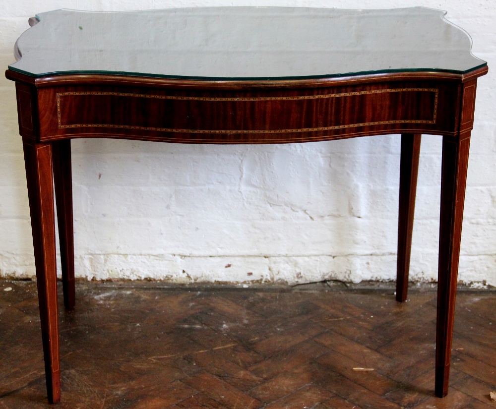 An Edwardian inlaid mahogany serpentine occasional table, on tapered square legs,