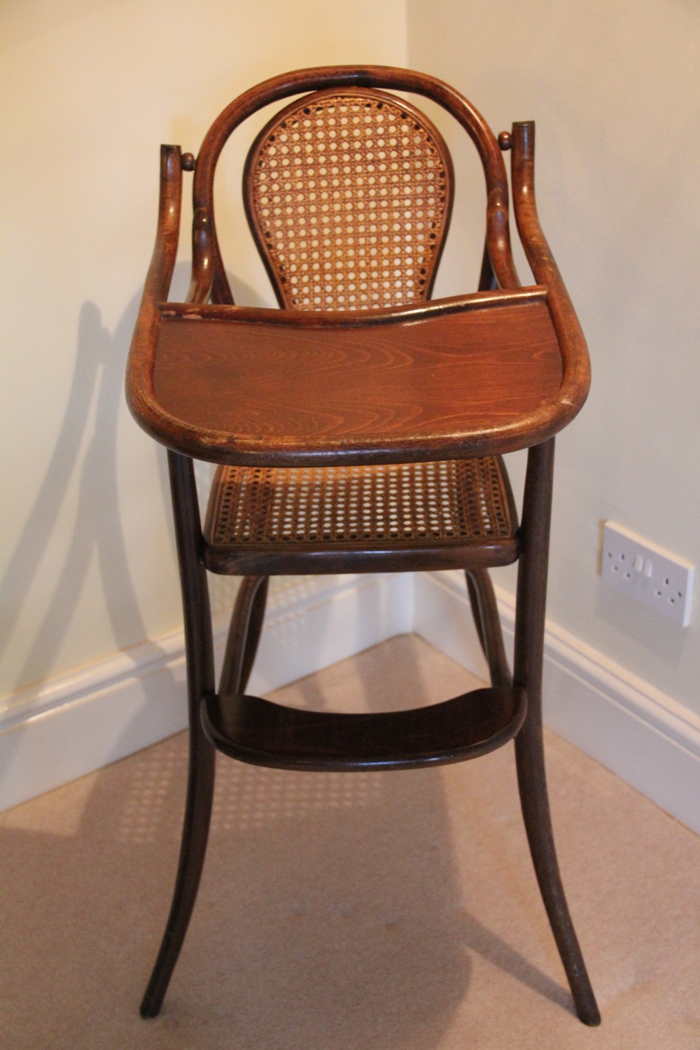 A Thonet style bentwood child's high chair, with caned back and seat on splayed legs,