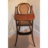 A Thonet style bentwood child's high chair, with caned back and seat on splayed legs,