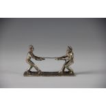 A Victorian silver plated knife rest, designed as two characters in a tug of war (at fault),