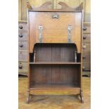 An Arts and Crafts oak students desk, the fall with copper strap hinges and escutcheon,