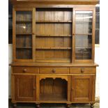 An early 20th century oak dresser, with two glazed doors over three drawers and two cupboard doors,