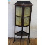 An Edwardian inlaid mahogany bow front corner cabinet, with undertier, on out-swept legs,