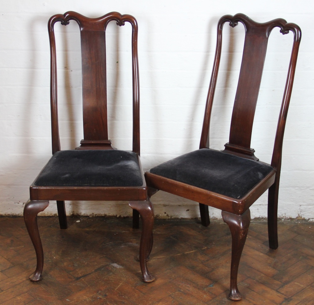 A set of four Edwardian mahogany dining chairs, with serpentine cresting rails and solid splats,