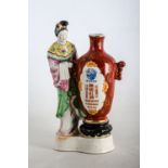 GRUPPO in porcellana policroma raffigurante "geisha con vaso". Cina XX secolo Misure: h cm 31,5