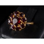 ANELLO in oro giallo 18 Kt. con fiore di granati sfaccettati (g. 6). Meta' '900