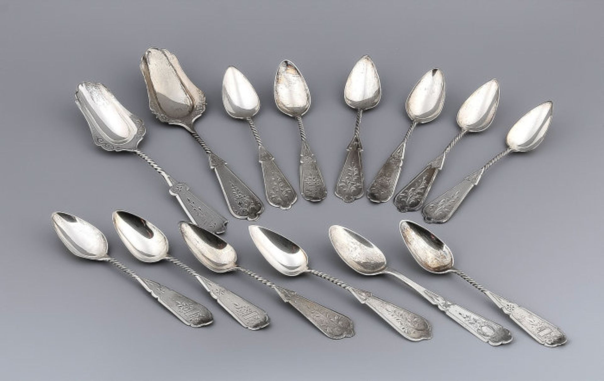 Twelve Dutch silver tea spoons with two silver sugar creation, all with twisted handle and scalloped