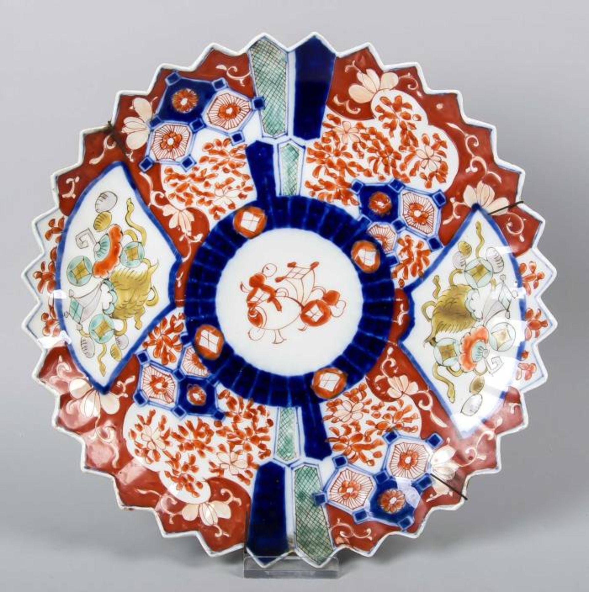Large 19th century Imari porcelain plate with serrated edge. Decor symbols and flora ø31cm.