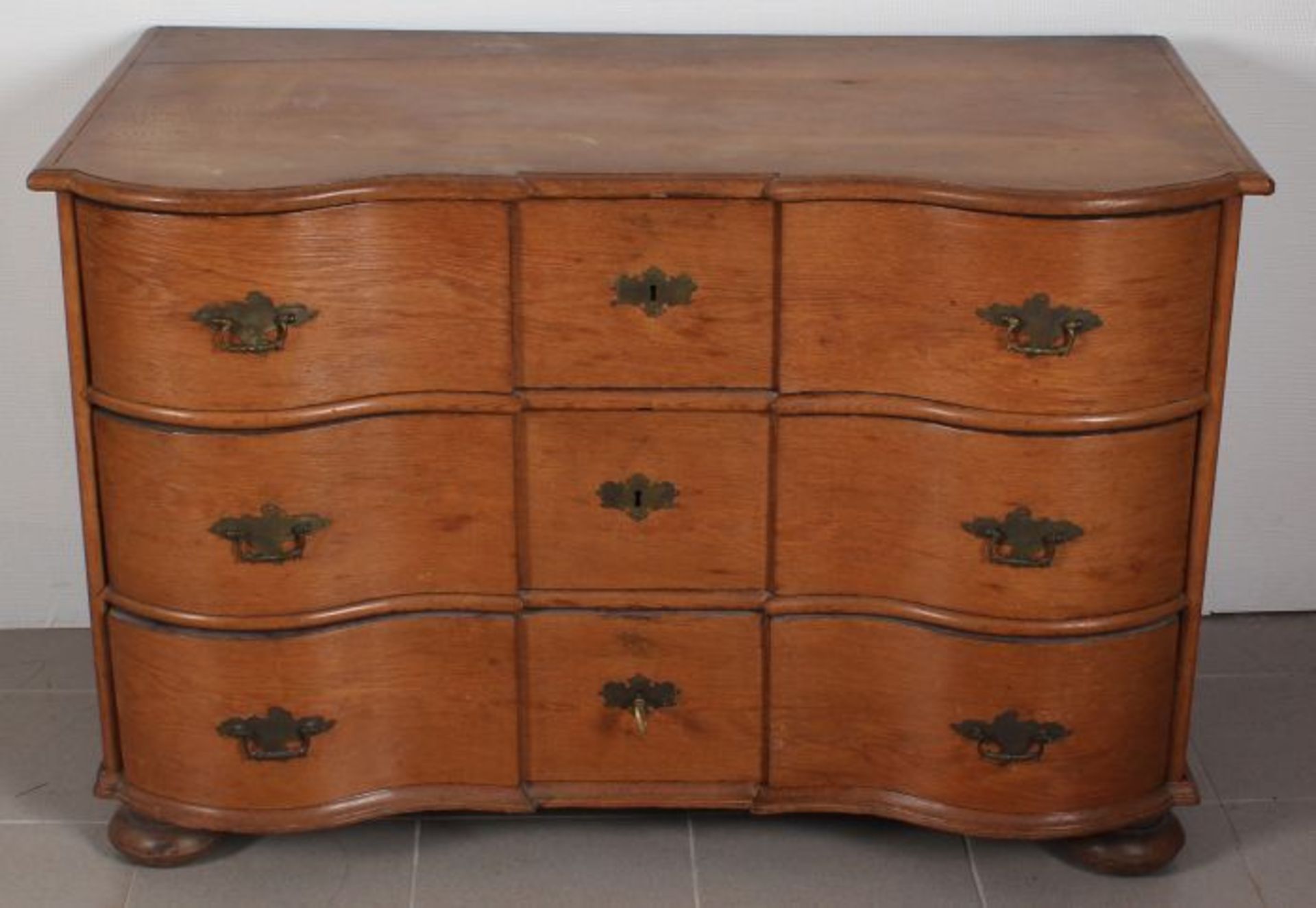 North German baroque 18th century oak chest of drawers, double curved with original lock and