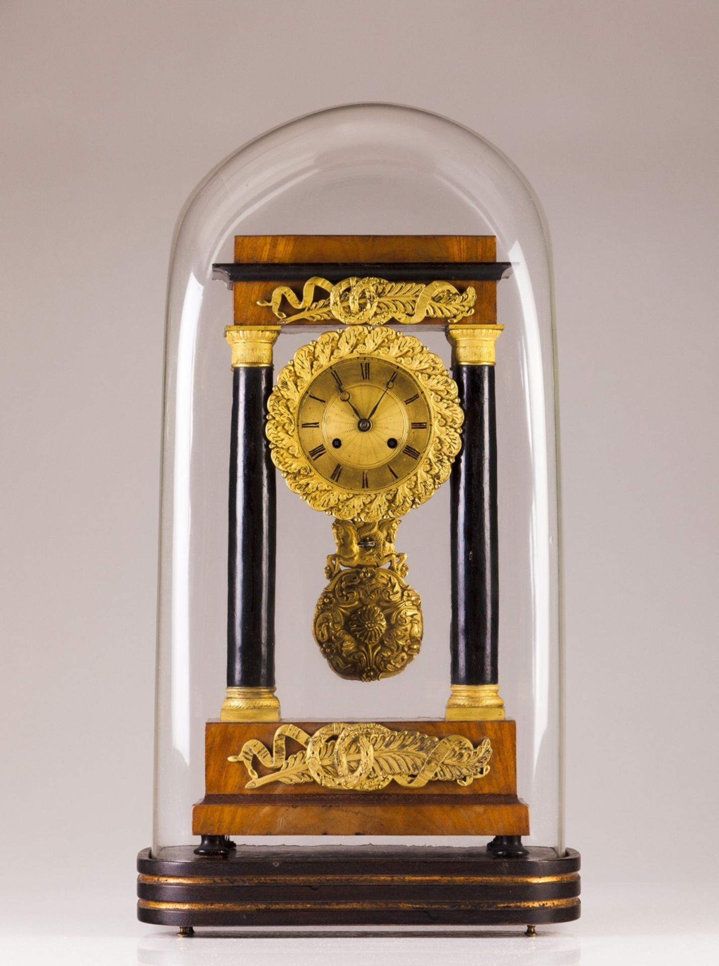 A 19th century Empire table clock  Verneered structure in walnut root and ebonized wood with