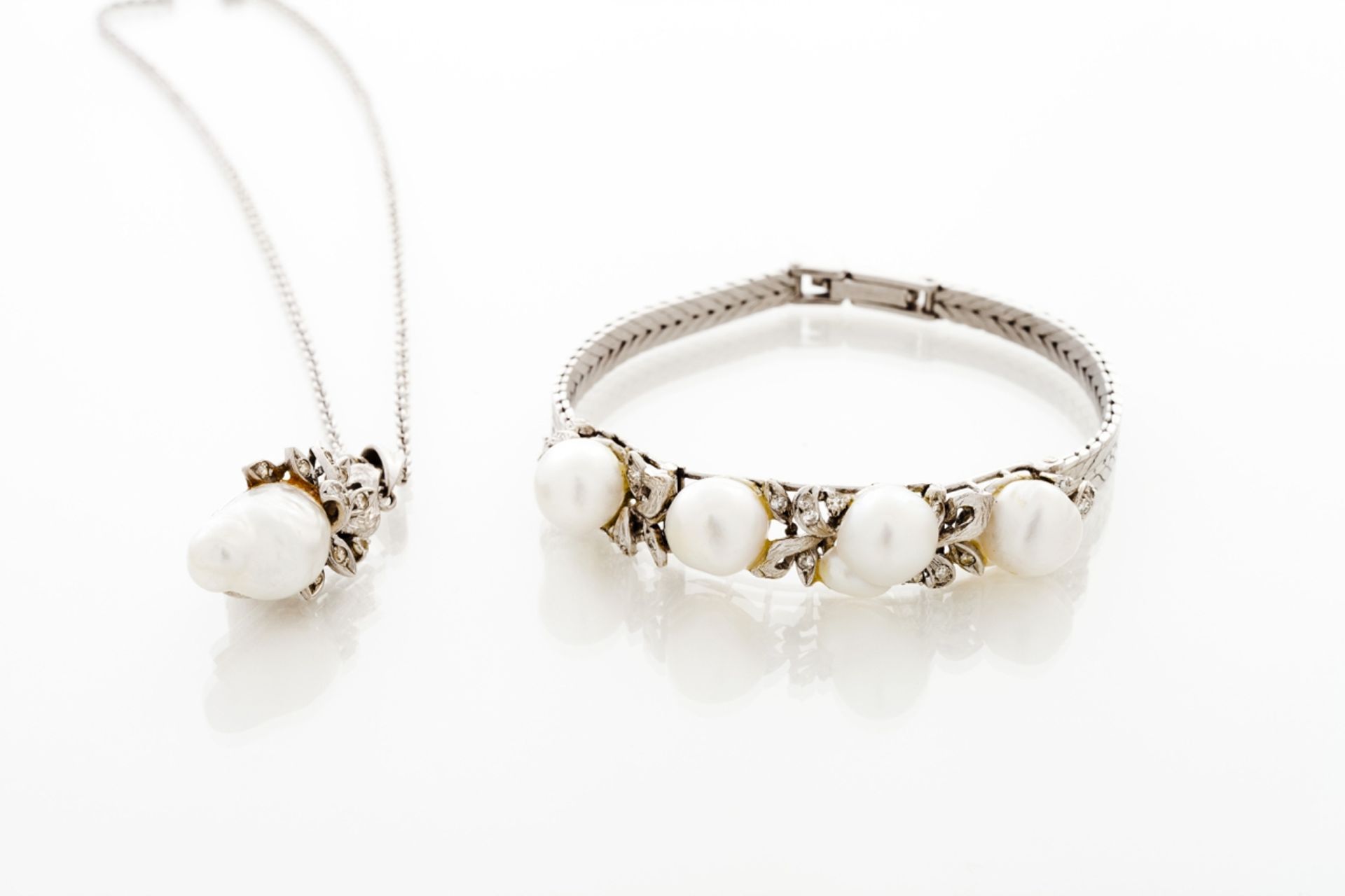 A cultured pearl and diamond bracelet  Set in 18kt gold with small single cut diamonds and four