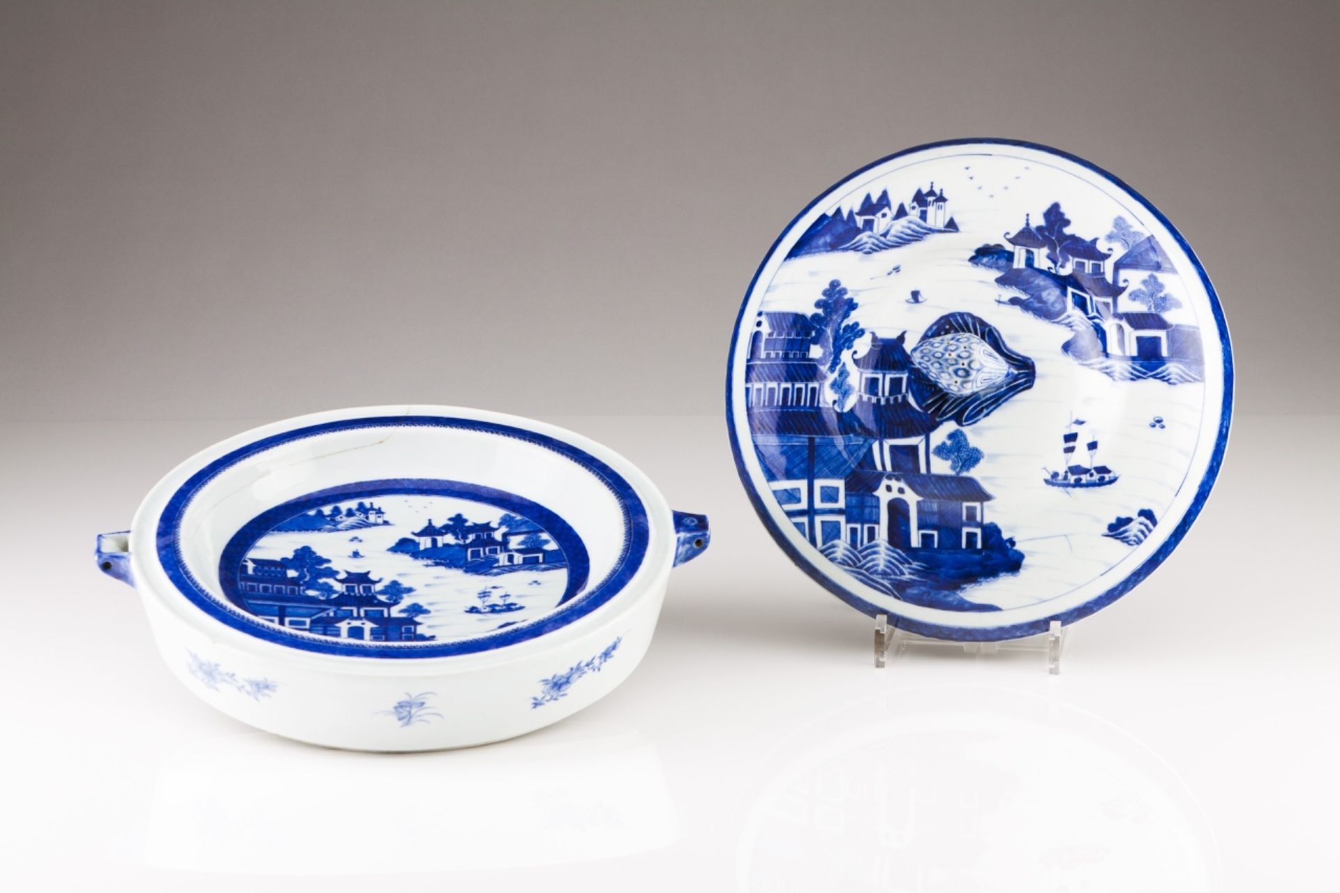 A large Jiaqing plate warmer
Chinese export porcelain
Blue "Canton" decoration riverscapes with