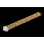 A gold bracelet
Gold mesh, clasp set in gold with turquoise cameo with rose cut diamond frame,