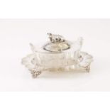 A silver-plated butter dish
Tray with relief and pierced decoration on four scroll feet, cut glass