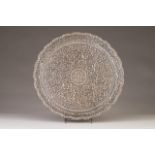 An oriental silver salver
Scalloped and pierced tab, profuse relief decoration with floral motifs,