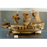 Decorative carved wooden ship on display stand,