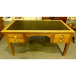 Large oak kneehole desk with four drawers and green leather inlaid top.