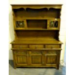 Oak Welsh dresser with lead glazed doors to top, three drawers over linenfold cupboards to base.