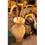 Large ceramic vase coated in wicker with the contents of three wooden walking sticks