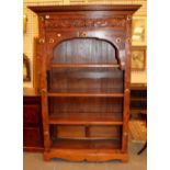 Four shelf bookcases in stained pine with detailed carving and brass rosettes