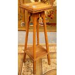 A golden oak two tier vintage plant stand with carved decoration.