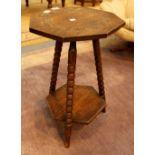 Carved octagonal oak topped table with three bobbin turned legs and under tier