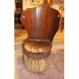 Bucket shaped chair carved with animal skin covered seat and bark base