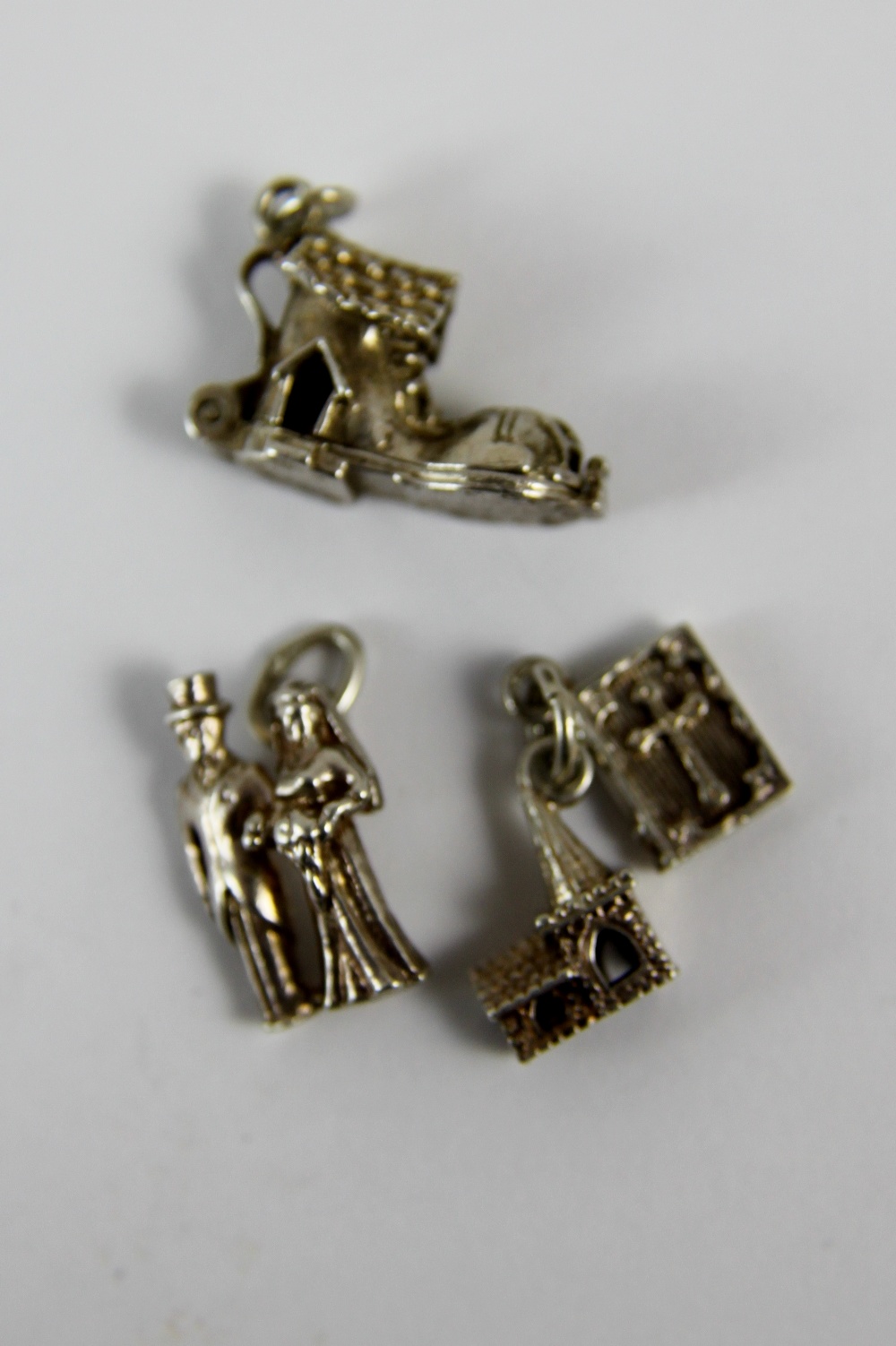 Three silver charms; bride and groom,