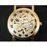Boxed yellow metal gents automatic skeleton wristwatch on brown leather strap,