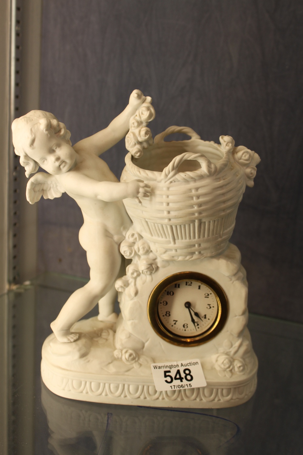 Bisque continental cherub vase with inset mechanical clock