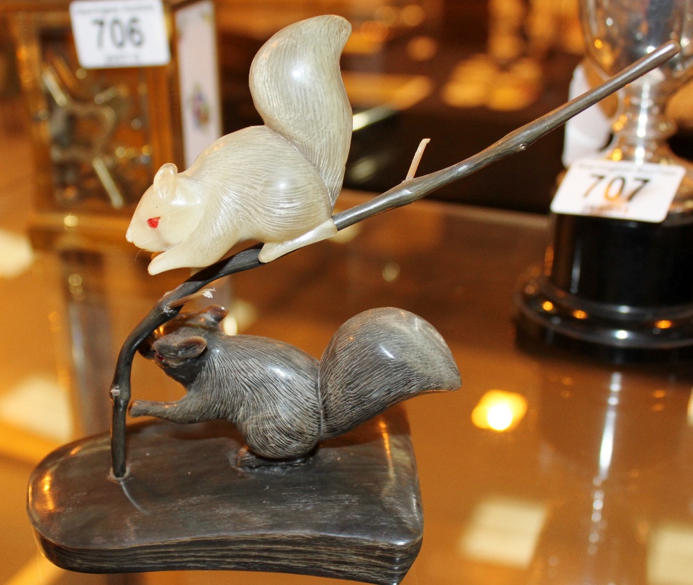 Pair of carved horn squirrels on a branch