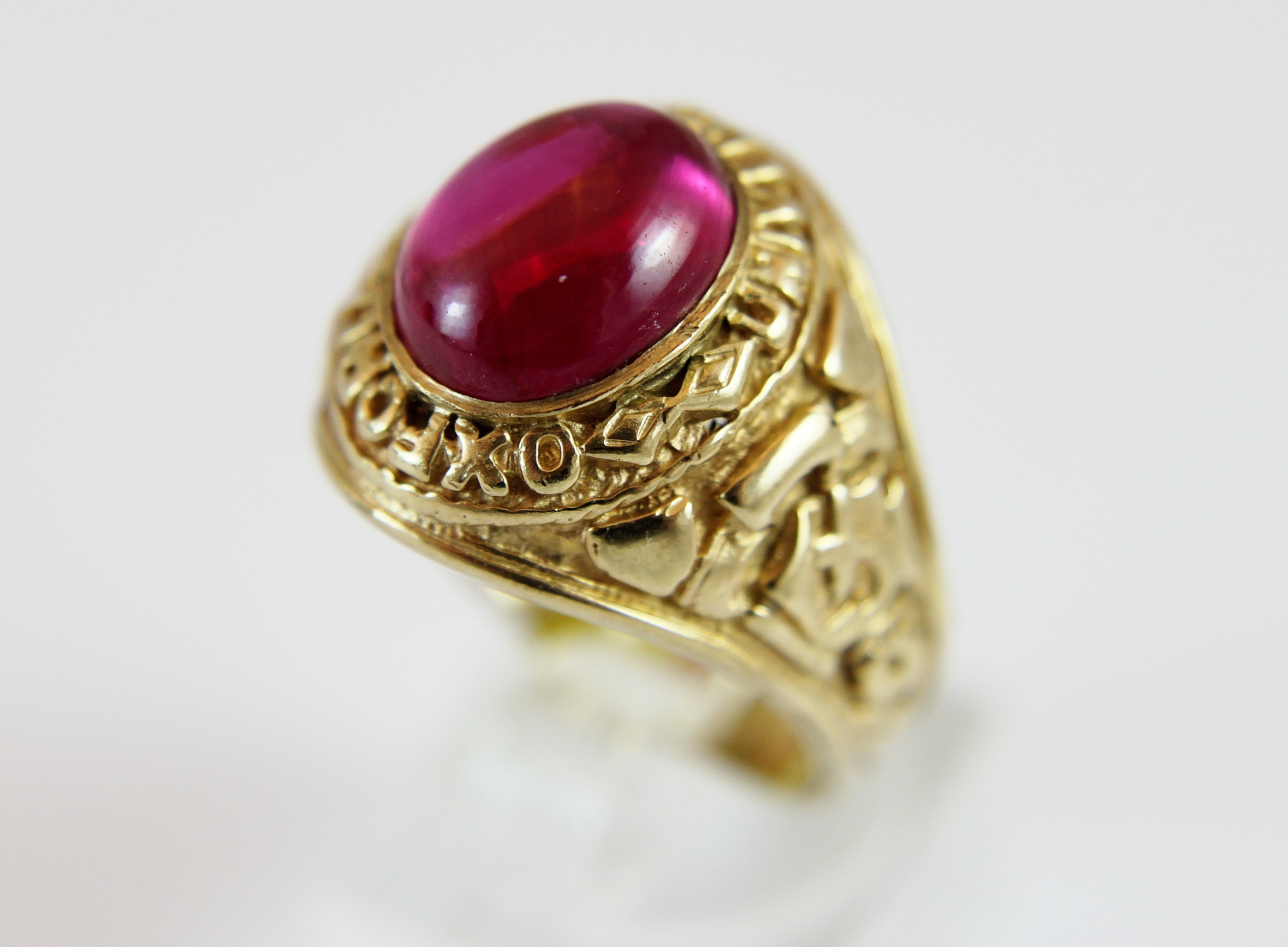 9 ct gold American style college ring set with red cabachon stone,