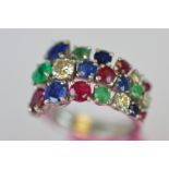 A stylish three row emerald, ruby, sapphire and diamond ring in 18ct white gold. Est. £600 - £650.