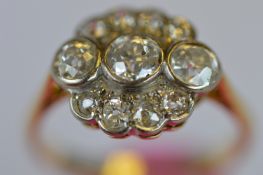 An attractive diamond oval cluster ring in colett shaped 18ct mount with rub over setting. Est. £460