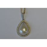 An 18ct white gold teardrop pearl pendant with diamond border and loop top on fine link chain.