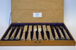 An attractive set of six plus six dessert forks and knives with fluted stems and silver blades in