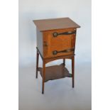 A stylish oak smoker's cabinet with elaborate handles and fitted interior in the manner of