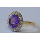 An attractive oval amethyst and diamond cluster ring. Est. £250 - £300.