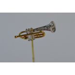 An unusual two colour gold stick pin in the form of a trumpet with diamond tip. Est. £140 - £160.