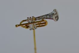 An unusual two colour gold stick pin in the form of a trumpet with diamond tip. Est. £140 - £160.