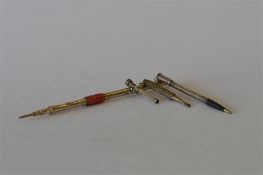An enamel mounted extending pencil together with two others. Approx 27 grams. Est. £20 - £30.