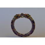 A heavy Eastern enamelled bangle decorated with flowers and leaves in the form of two serpents