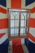 An Edwardian glazed two door cabinet with string inlay. Est. £80 - £90.
