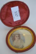 An attractive oval portrait of a lady with wavy hair, in velvet box. 7cms x 5cms. Est. £30 - £40.