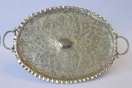 A heavy Eastern two handled tray with engraved handles. Approx 590 grams. Est. £160 - £180.