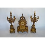 An impressive French brass clock garniture heavily embossed with flowers, scrolls and leaves with