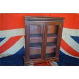 An Edwardian carved bookcase with glazed doors on bracket feet. Est. £200 - £250.